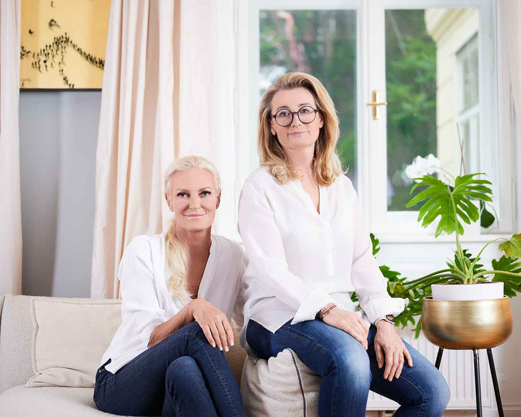 Gruppenbild 2 Ärztinnen auf der Couch im Wohnzimmer